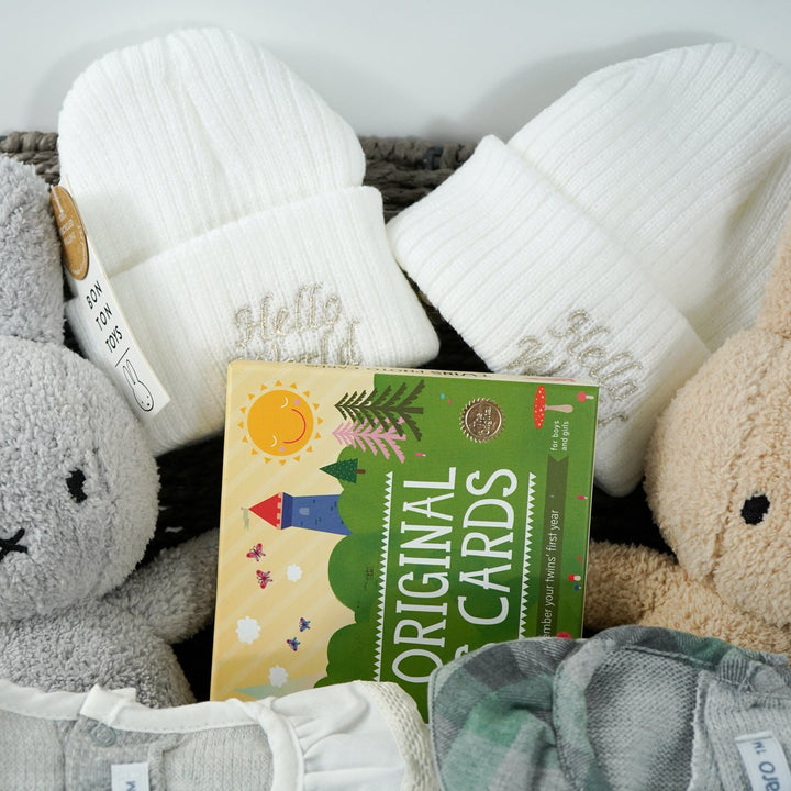 twin baby hamper  with 2 baby rompers in green and grey, white baby beanie hat, 2 x miffy one grey one biscuits colour, twins milestone cards 