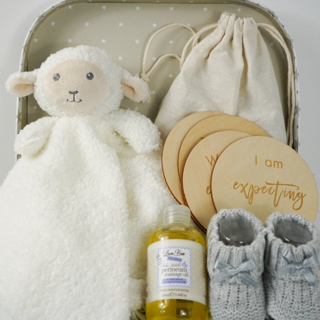 pregnancy hamper in a grey with white star case lamb comforter, grey booties, perineum oil, pregnancy milestone discs