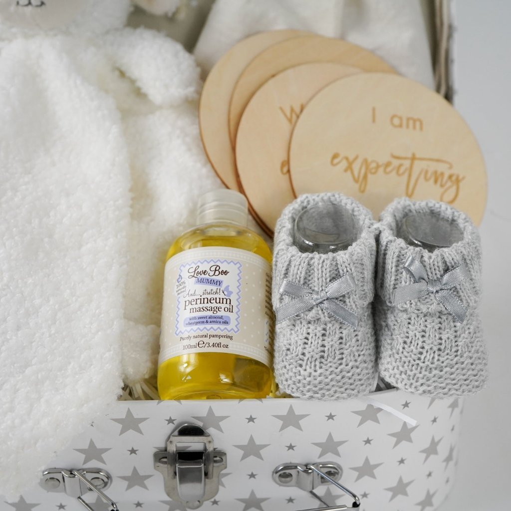 pregnancy hamper in a grey with white star case lamb comforter, grey booties, perineum oil, pregnancy milestone discs