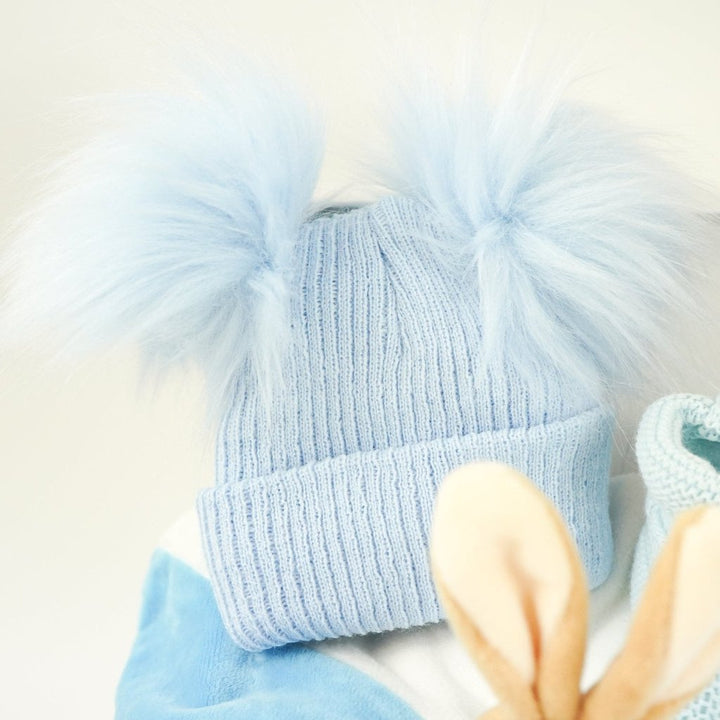 blue baby hamper with Peter Rabbit baby comforter , blue double pompom hat and blue knit booties 