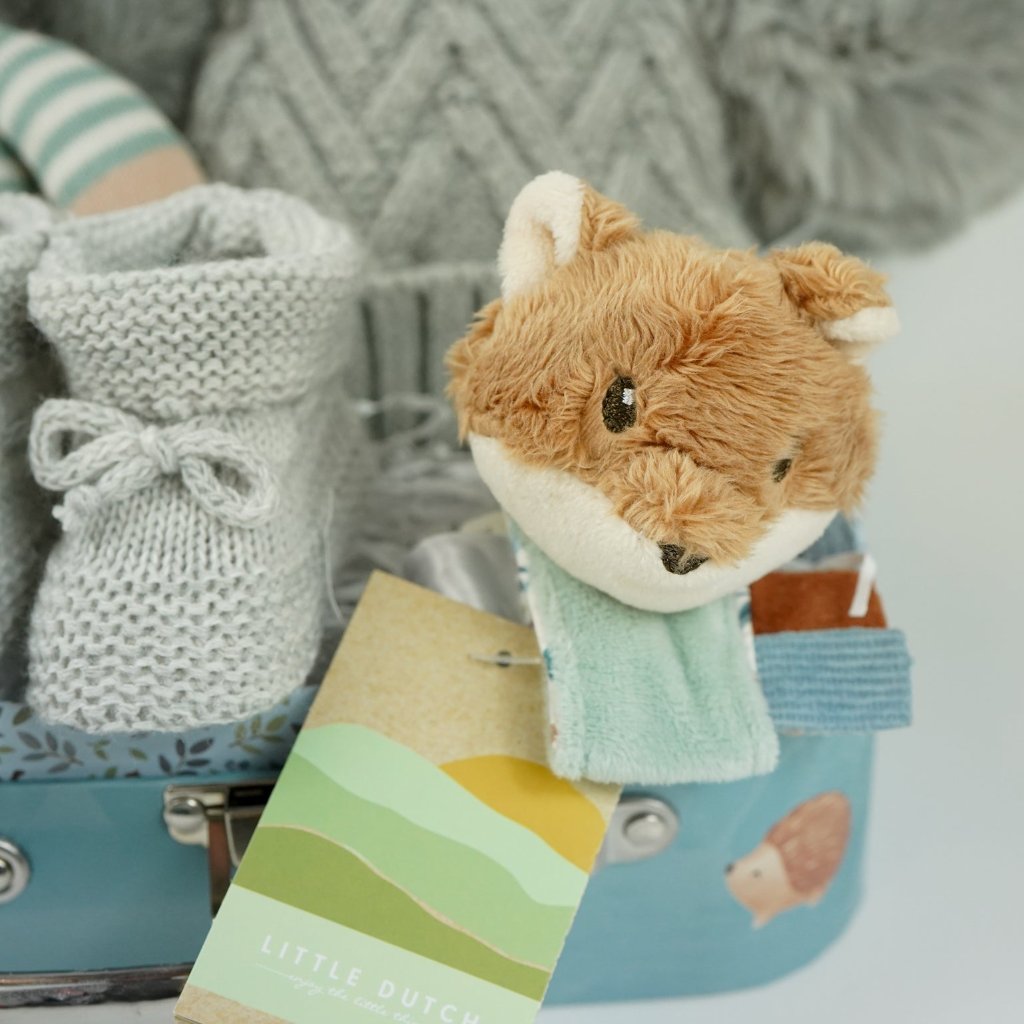 small case with soft knit baby rabbit toy, cuddly fox head wrist rattle, knit booties and double pompom grey knit baby hat