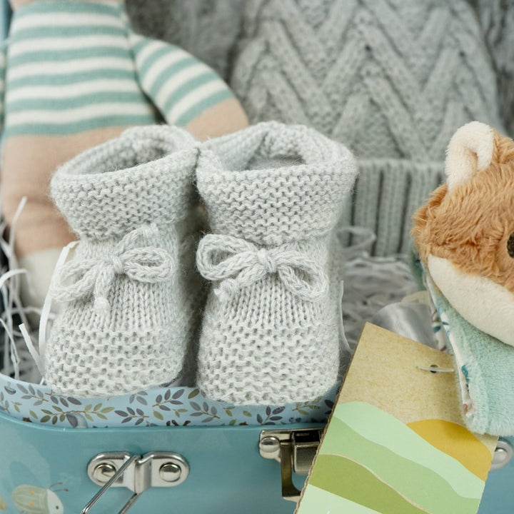 small case with soft knit baby rabbit toy, cuddly fox head wrist rattle, knit booties and double pompom grey knit baby hat