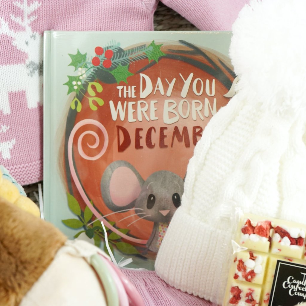 baby girl christmas hamper, Little Dutch soft activity deer, December baby book, baby pink knit Christmas outfit with white reindeer, wooden push along duck, Eaton mess chocolate bar, knit pom pom hat