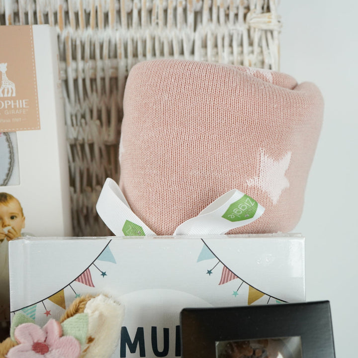 uxury mum and baby hamper, luxury pink velour sleepsuit with gold angel wings embroidery, pink star knit blanket, soft pink deer comforter,  ivory alpaca baby slippers, 4 sophie la giraffe muslins, box of chocolate domes, mum to mum tips book