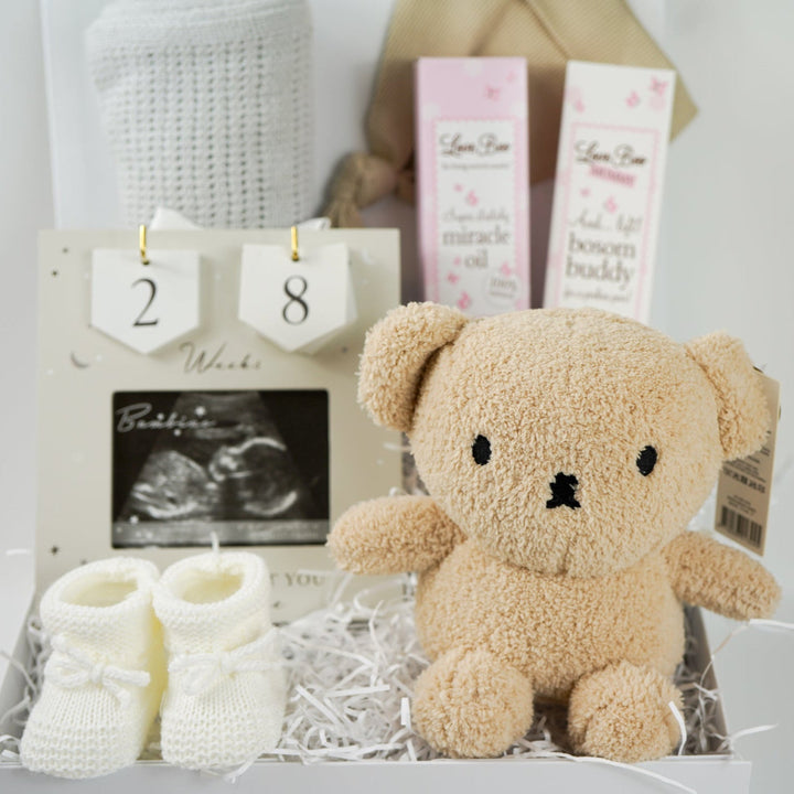 pregnancy hamper box, grey cellular baby blanket, biscuit coloured knot baby hat, antenatal toiletries, soft miffy teddy in biscuit, white knit booties, scan picture frame with pregnancy wooden countdown discs