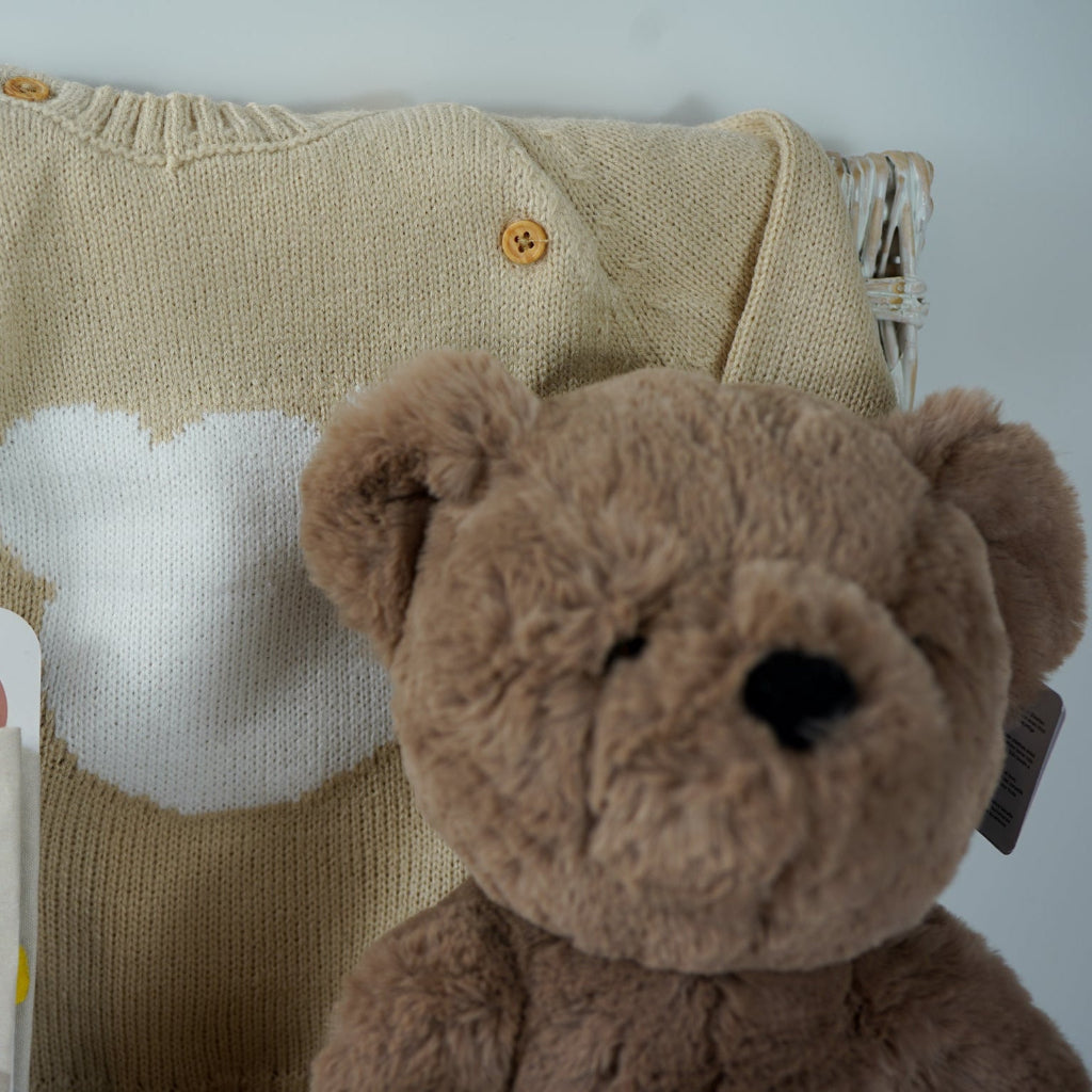 teddy bear themed baby hamper, beige and white baby knit clothing set with jumper, stripe knit leggings, hat and mittens, fabric baby book, 2 pairs of cream baby socks with teddy bear design , fabric baby book, baby shampoo and body wash, fabric book