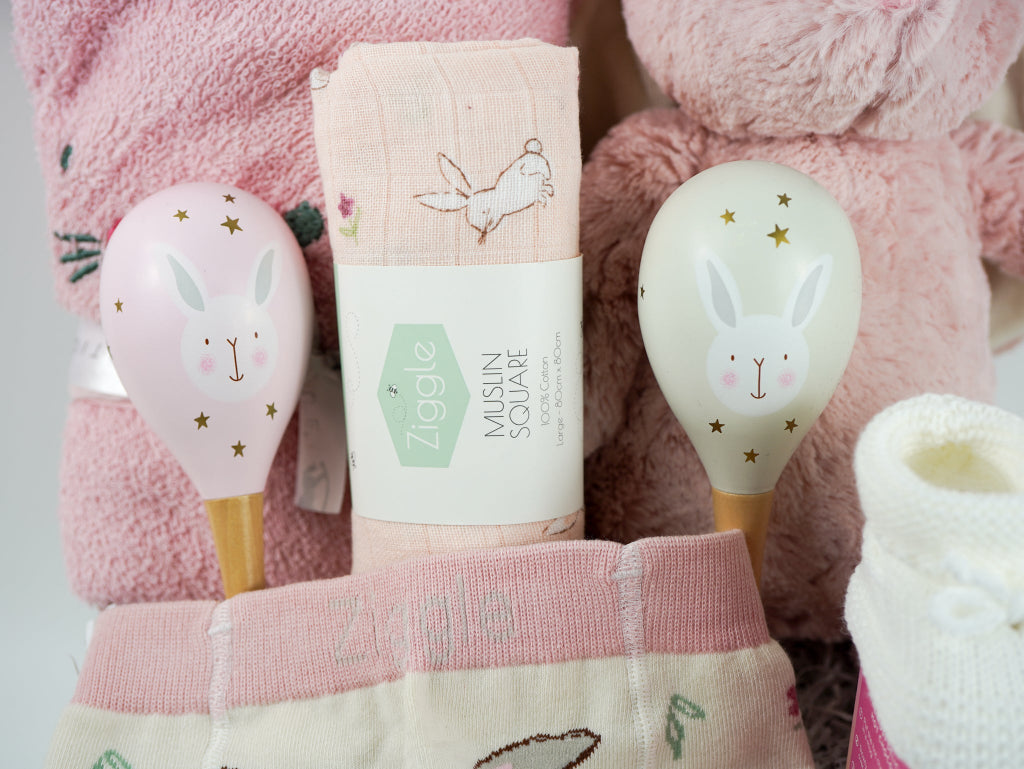 pink bunny baby hamper, pink hooded towel with bunny ears, soft bunny rabbit, bunny muslin, pink knit baby girl leggings with bunny on the  bum and matching socks with bunny, maracas in pin and grey with bunny face, white booties, , white chocolate bomb