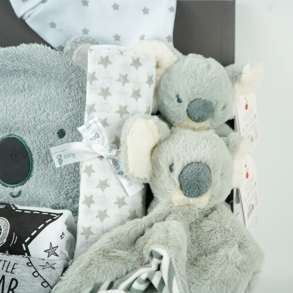 koala themed baby hamper box with koala grey hooded baby towel, white and grey cotton knot hat, white and grey muslin, Koala soft toy, Koala comforter , 2 x cotton white milestone vests newborn , 3 months and 6 months , white knit booties