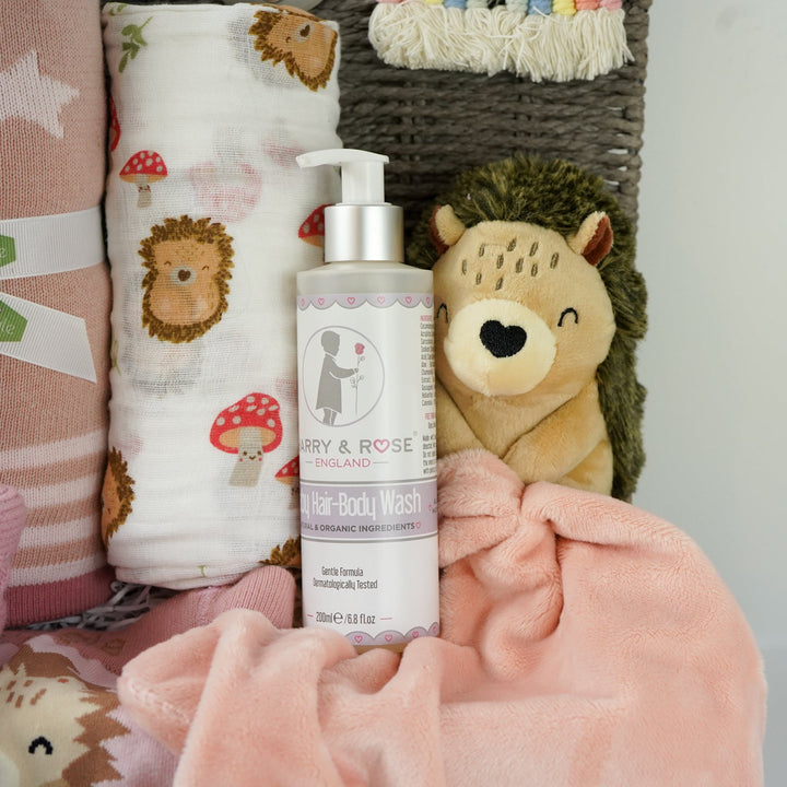 hedgehog themed baby hamper with pink striped hedgehog knit baby leggings and matching socks, baby pink star blanket, baby swaddle with hedgehogs , hedgehoge taggie comforter, baby knit booties, organic baby bath