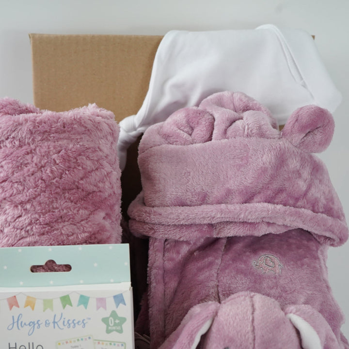 aby gift set with pink plush baby comforter in pink with matching dressing gown and blanket all in a dusky pink fleece , baby white knot hat and white knit booties and baby milestone cards packaged in a  box