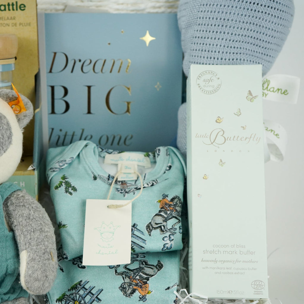uxury baby boy gift hamper with blue rain rattle, dream big photo album in blue . blue bamboo cellular blanket, luxury GOTs panda soft toy by Steiff, Luxury baby boy pyjamas with cowboys, mum stretch mark cream