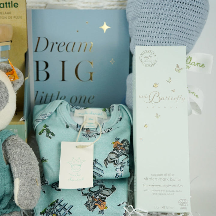 uxury baby boy gift hamper with blue rain rattle, dream big photo album in blue . blue bamboo cellular blanket, luxury GOTs panda soft toy by Steiff, Luxury baby boy pyjamas with cowboys, mum stretch mark cream