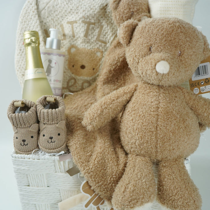 teddy themed baby gift hamper, neutral cream baby cardigan with embroidered teddy on the back, soft Nattou teddy with matching comforter, caramel coloured baby teddy booties, baby organic wash, no alcohol prosecco
