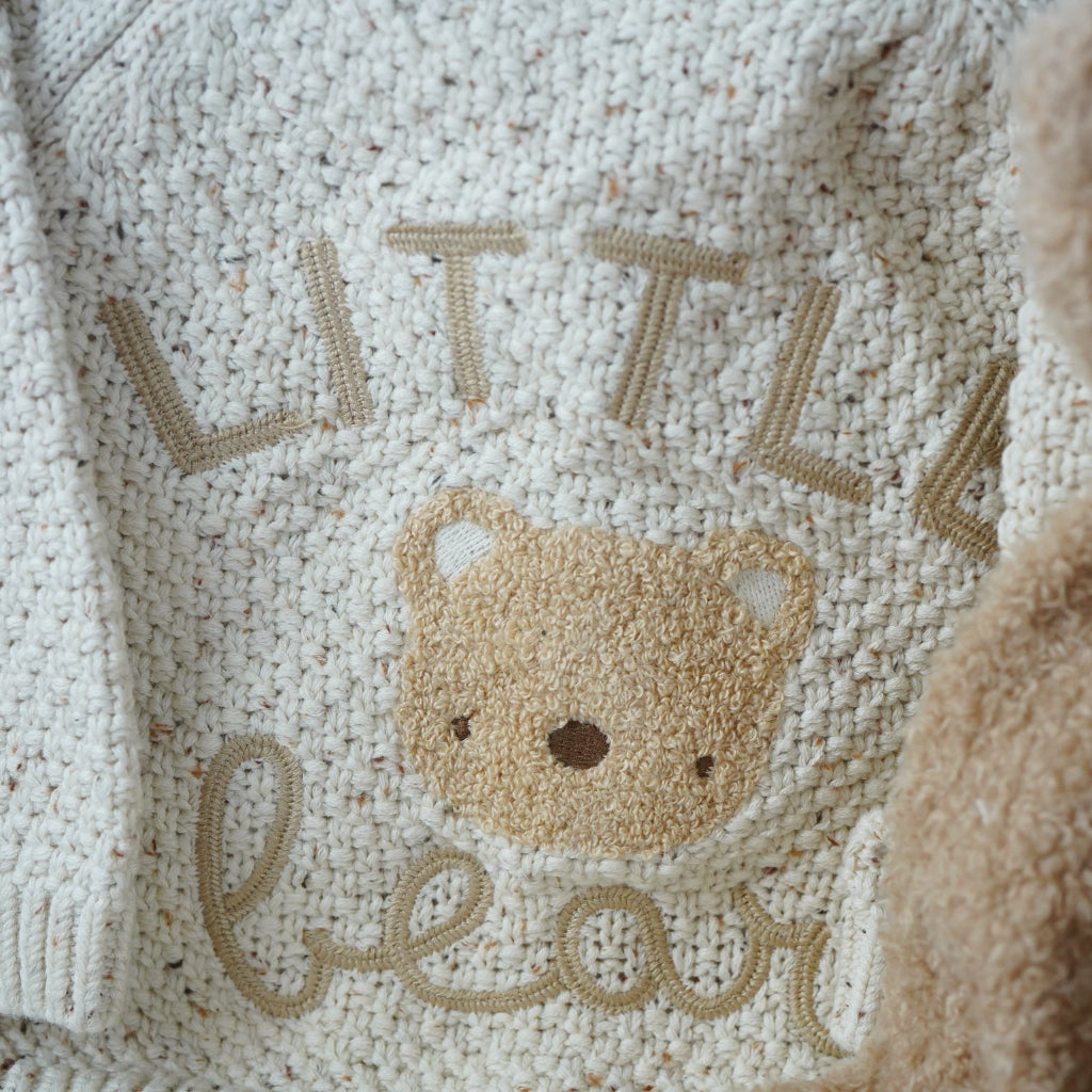 teddy themed baby gift hamper, neutral cream baby cardigan with embroidered teddy on the back, soft Nattou teddy with matching comforter, caramel coloured baby teddy booties, baby organic wash, no alcohol prosecco