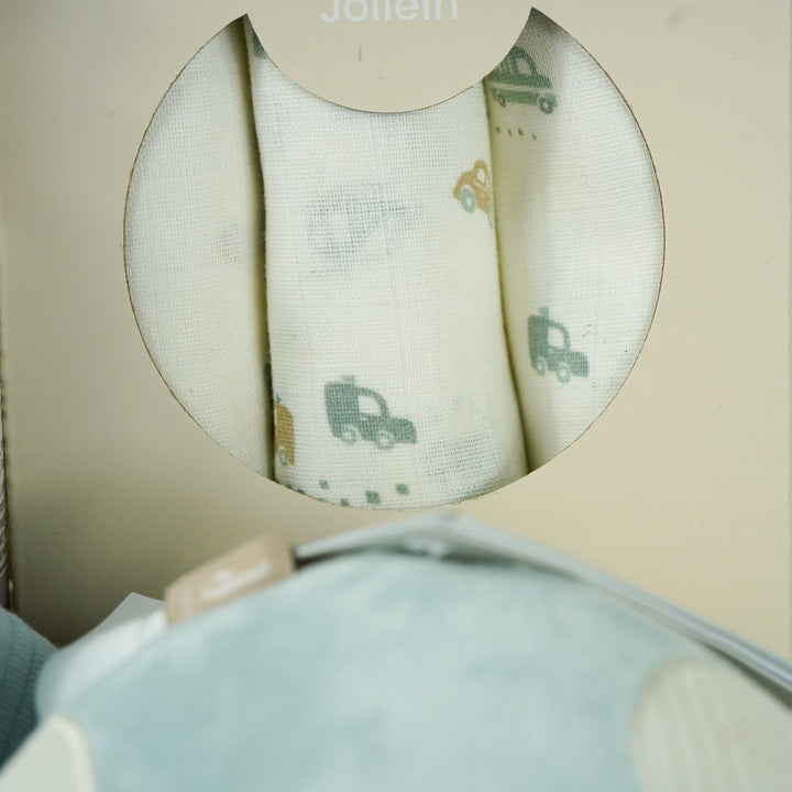 baby hamper with blue zip up baby sleepsuit, baby muslin basket in white with grey elephants, toiletries for baby, three muslins in cream with cards , car soft activity toy, white baby booties with rabbit face, silicon baby teether with 2 cars and keys in blues and cream