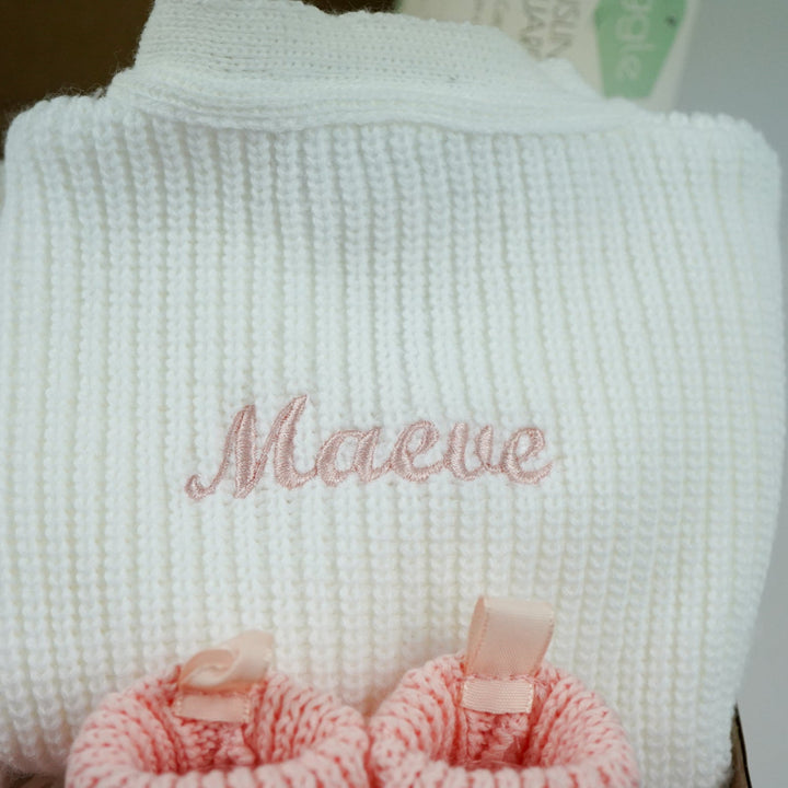 baby gifts in a eco friendly outer box includes white knit baby ribbed cardigans x 2 and pink booties with bows x 2 and pink muslin squares with bunnies x 2 