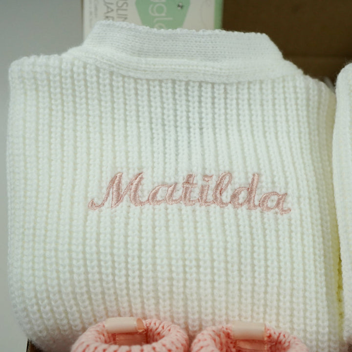 baby gifts in a eco friendly outer box includes white knit baby ribbed cardigans x 2 and pink booties with bows x 2 and pink muslin squares with bunnies x 2 