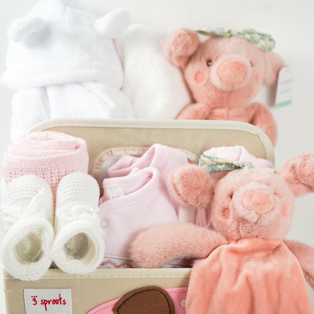 nappy caddy baby hamper gift with baby dressing gown white with cute ears, baby white hooded towel with pink/white edging, baby girl clothing set, pink pig soft toy with green headband and matching comforter, white baby booties, pink cellular blanket
