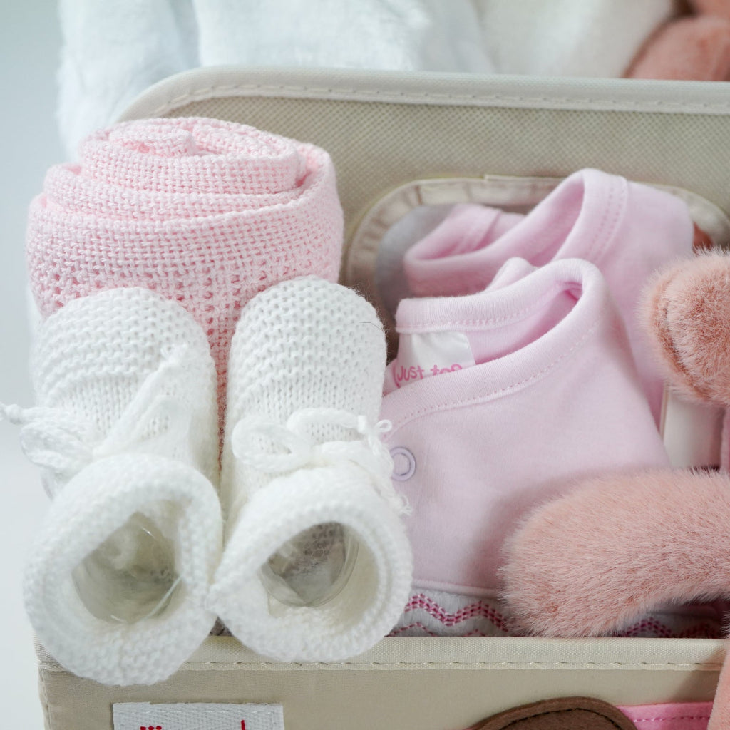 nappy caddy baby hamper gift with baby dressing gown white with cute ears, baby white hooded towel with pink/white edging, baby girl clothing set, pink pig soft toy with green headband and matching comforter, white baby booties, pink cellular blanket