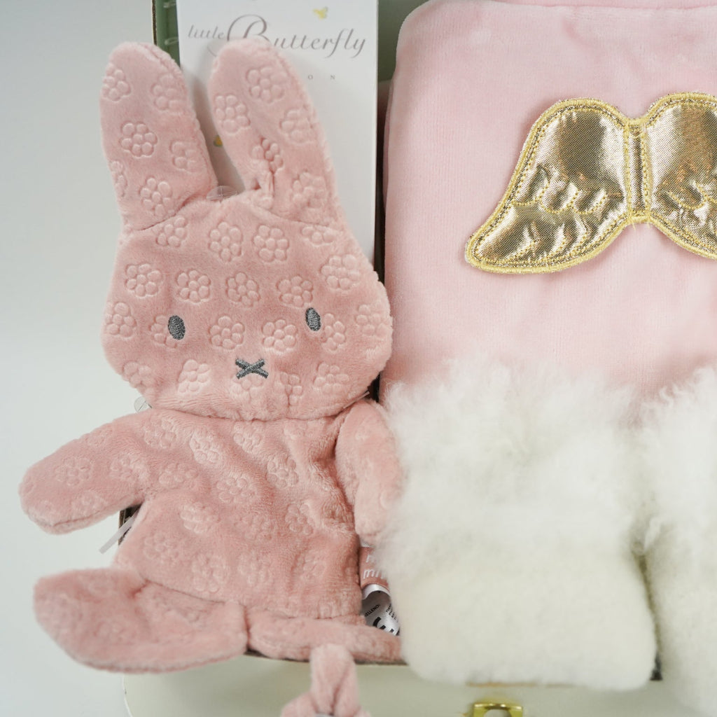luxury baby girl gift, pink velour sleepsuit with gold angel wings by Marie-Chantal, alpaca white baby slippers, Organic baby toiletries  and pink miffy comforter 