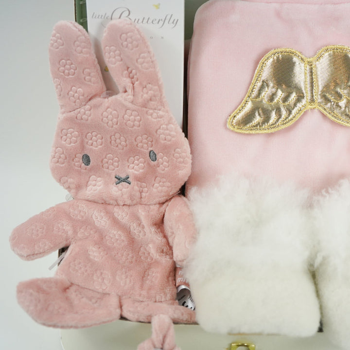 luxury baby girl gift, pink velour sleepsuit with gold angel wings by Marie-Chantal, alpaca white baby slippers, Organic baby toiletries  and pink miffy comforter 