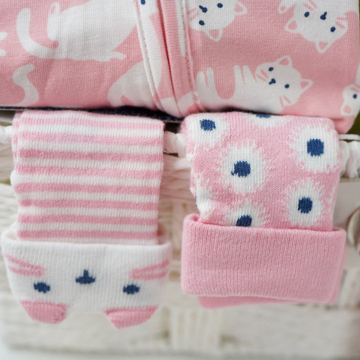 aby gift basket with pink plush toy, pink organic baby clothes, baby pink wrap with kittens, pink organic baby blanket, milestone cards, organic body wash and bottlle of nonsecco 