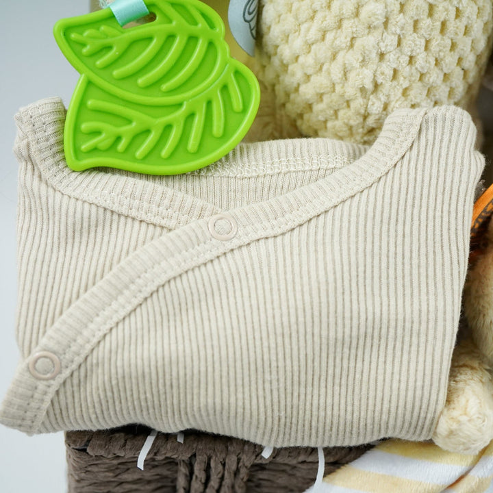 Grey paper rope neutral baby hamper with winnie the pooh comforter and pram toy, baby hooded dressing gown in caramel colour and baby sleepsuit, baby organic bubbles, non alcoholic freixenet and milestone cards 