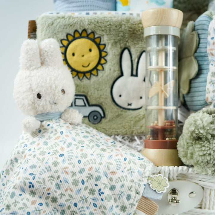 miffy themed baby hamper with green soft book, activity cube in pastel shades of green, white and blue, miffy soft rattle and matching comforter, rain rattle, blue cellular blanket, white muslin swaddle with bluebirds, fluffy green hat with ears and matching booties 