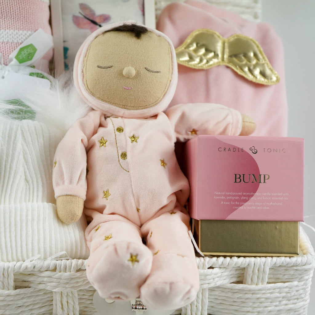 baby girl gift hamper with pink dozy dinkum soft musical doll. baby blanket , white fluffy hat, pink luxury candle, soft luxury baby outfit and swaddle in white with pink butteflies 