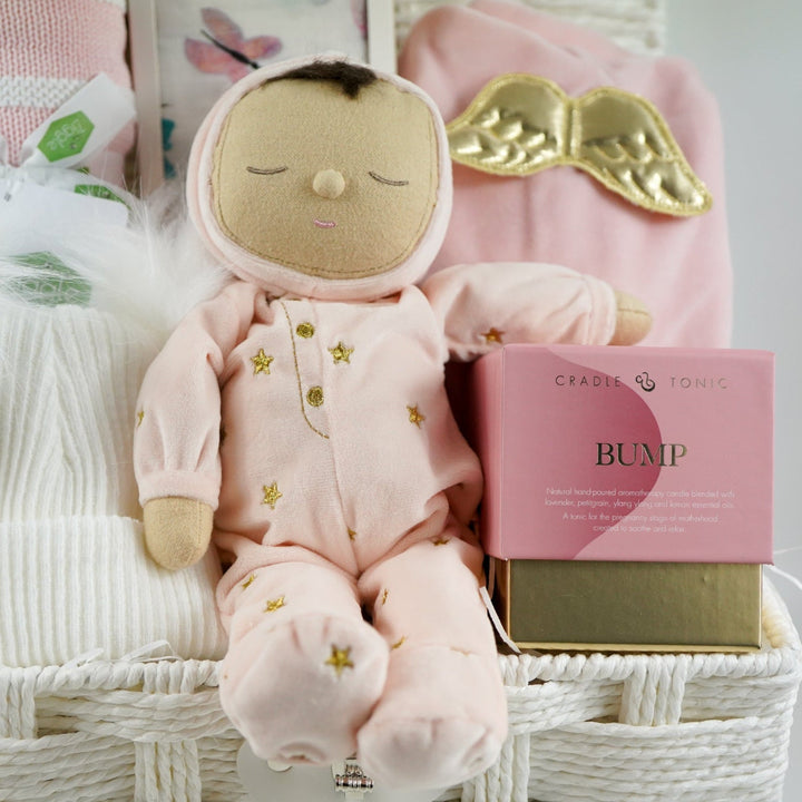baby girl gift hamper with pink dozy dinkum soft musical doll. baby blanket , white fluffy hat, pink luxury candle, soft luxury baby outfit and swaddle in white with pink butteflies 