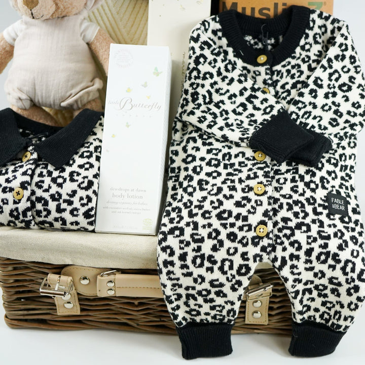 organic baby hamper with cream and black leopard prink knitted romper and  cardigan and matching hat in organic cotton, organic cotton cream blanket, organic steiff teddy, organic toiletries , organic black and white muslins and wooden sutainable hairbrush