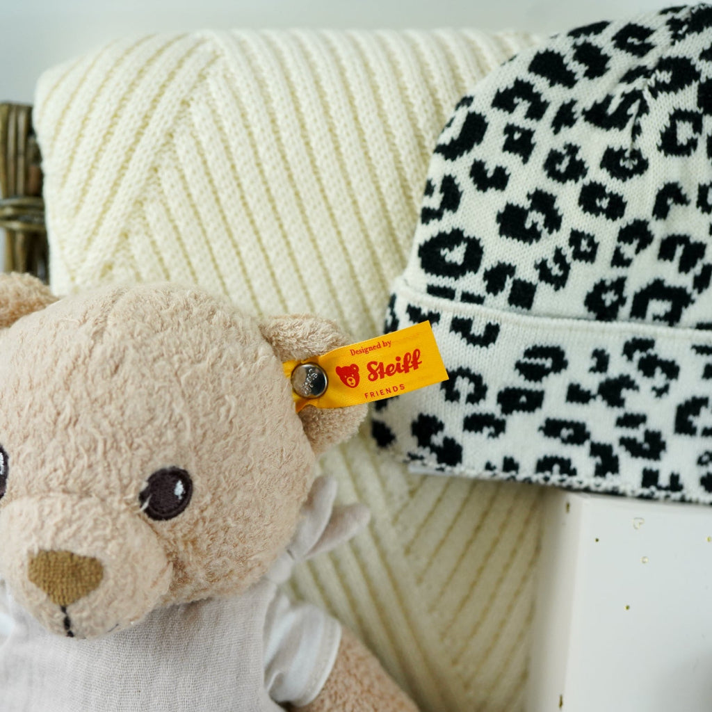 organic baby hamper with cream and black leopard prink knitted romper and  cardigan and matching hat in organic cotton, organic cotton cream blanket, organic steiff teddy, organic toiletries , organic black and white muslins and wooden sutainable hairbrush