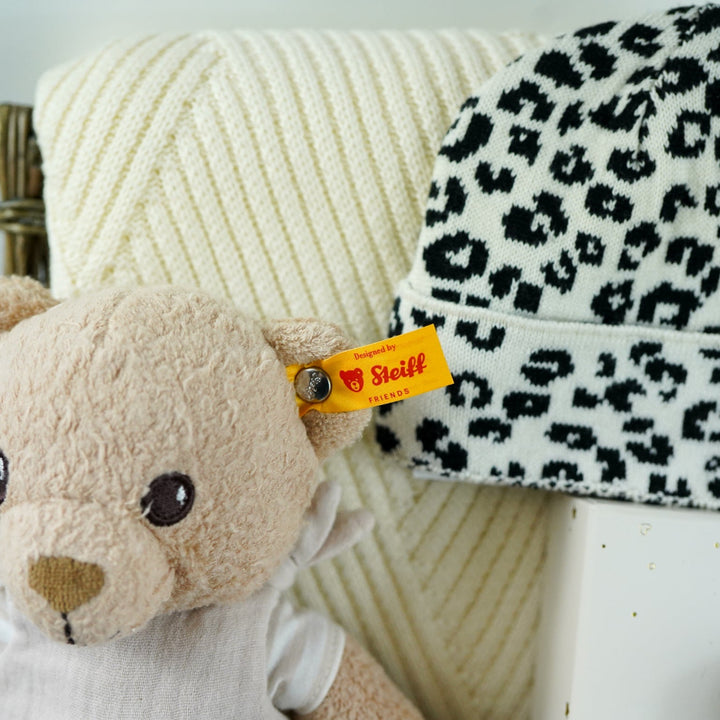 organic baby hamper with cream and black leopard prink knitted romper and  cardigan and matching hat in organic cotton, organic cotton cream blanket, organic steiff teddy, organic toiletries , organic black and white muslins and wooden sutainable hairbrush