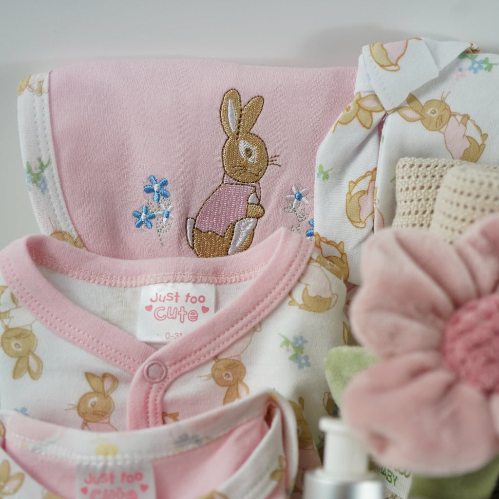 baby girl gifts in white hamper basket with baby layette, rose rattle, cellular blanket, Flopsy bunny soft toy, mum tips book , booties x 2 , baby comforter