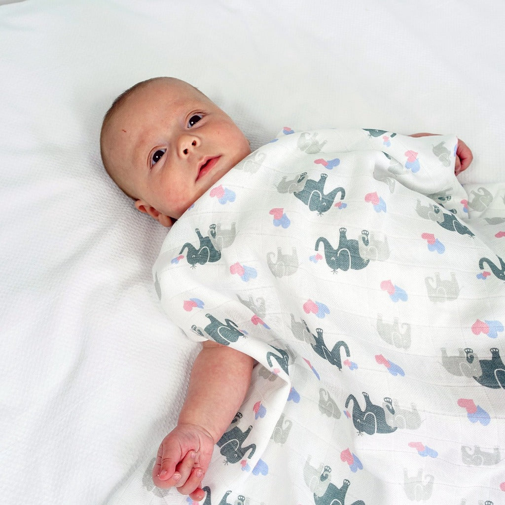 baby muslin swaddle in white with grey elephants and pink and blue hearts