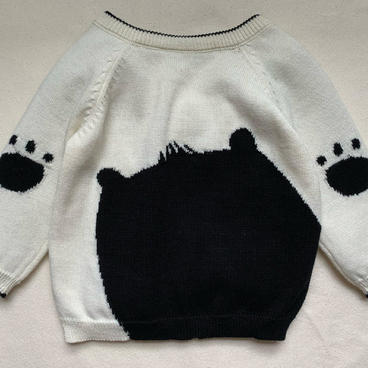 Cream and black baby jumper with a bear face and paws on the back