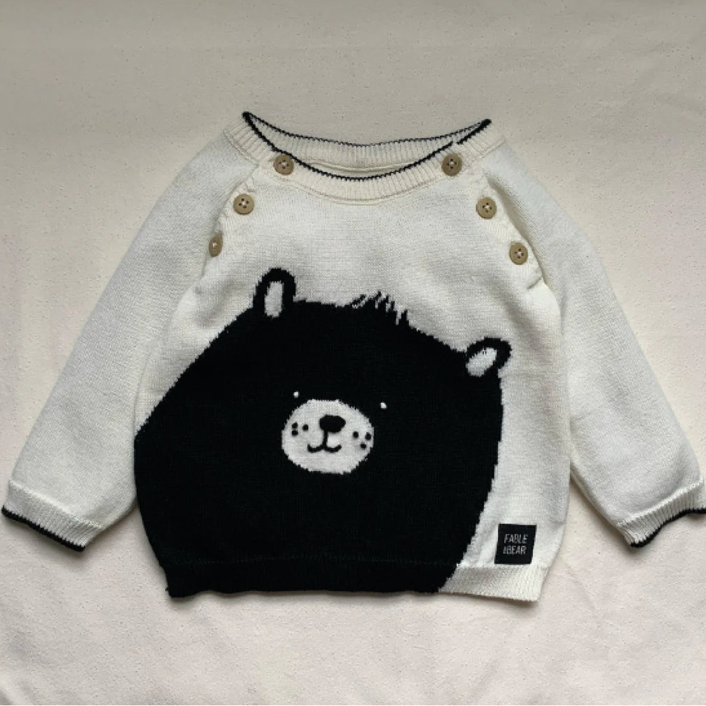 Cream and black baby jumper with a bear face and paws on the back