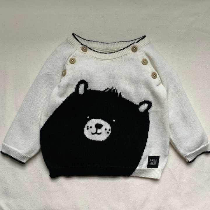 Cream and black baby jumper with a bear face and paws on the back