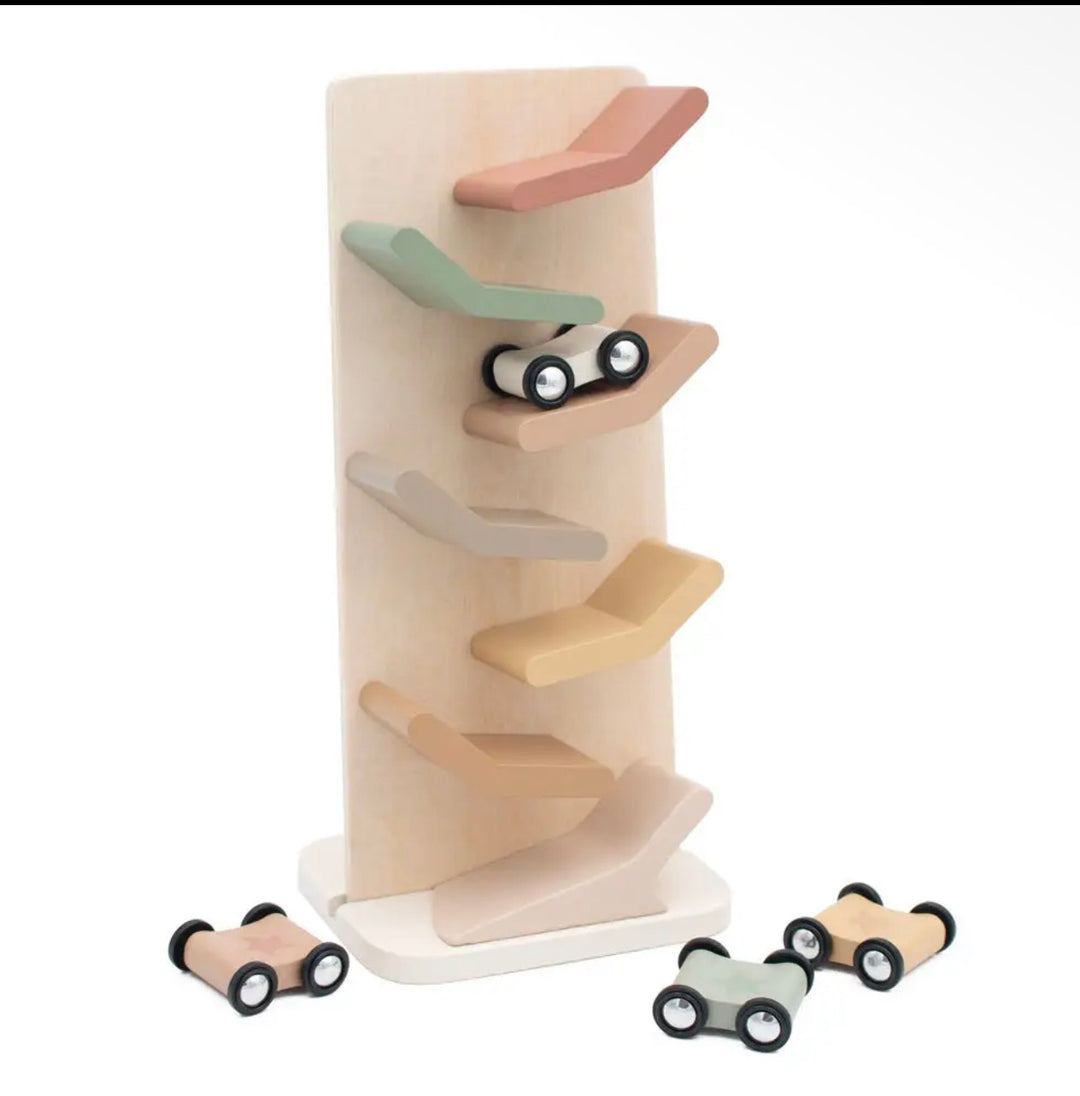 A wooden toy car rally track set on a white background, featuring a light natural wood vertical track with multiple curved ramps in muted pastel colors and several small wooden toy cars with black wheels.