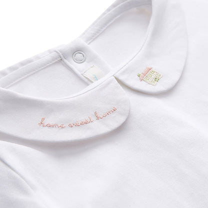 white onesie with home sweet home embroidered on one collar and a house on the other