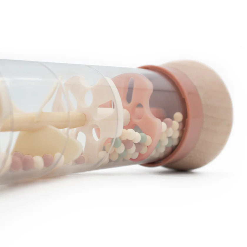 Clear tube with pink and beige silicone teethers on a white background