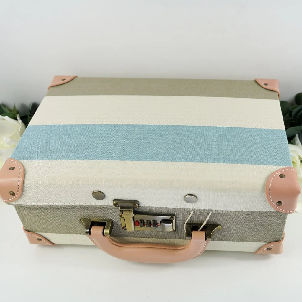 luxury baby keepsake case with luxury gifts, Steiff organic teddy with blue rompers , blue cashmere baby romper, baby toiletries organic, blue cotton blanket with star design, blue and white striped romper in organic cotton with embroidery on both sleeves, fluffy cream baby slip on slippers, wooden rattle with blue beads