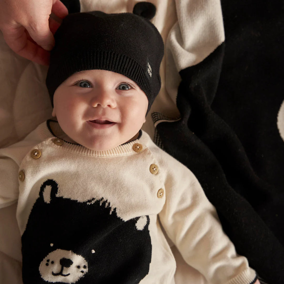 Cream and black baby jumper with a bear face and paws on the back