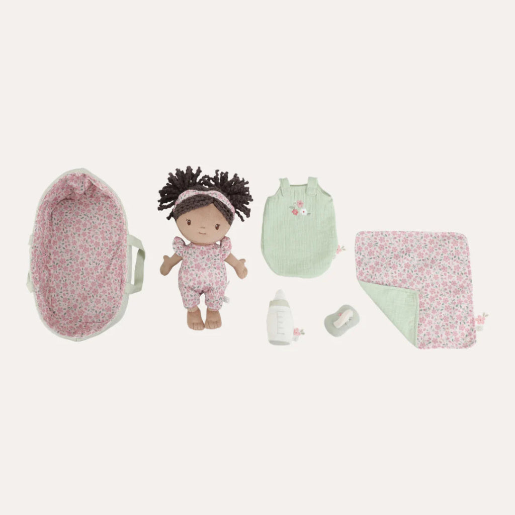 soft baby doll in a green fabric basket with a dummy, bottle and sleeping bag 