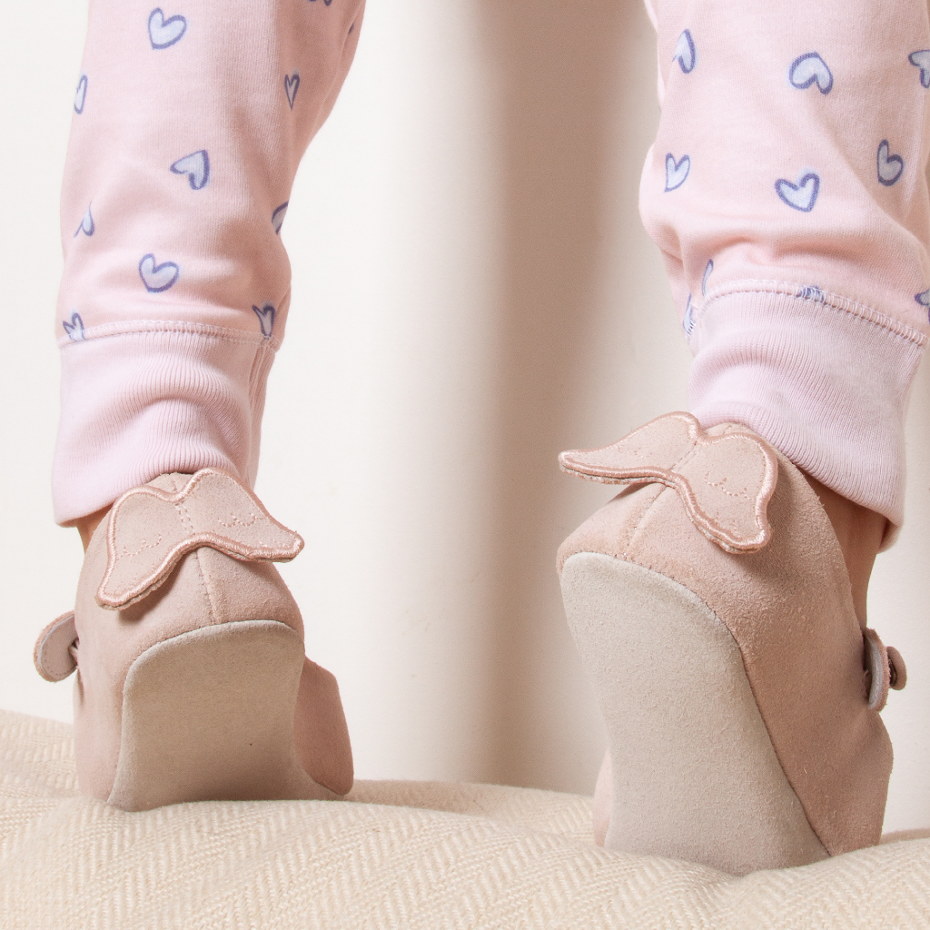 Pink suede baby slippers with angel wings on the back