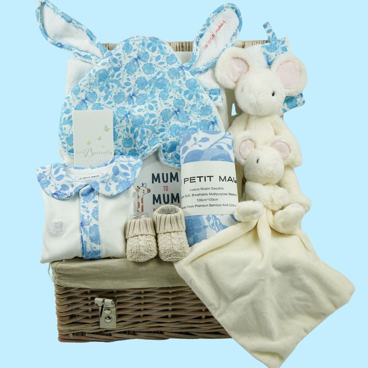 Luxury baby boy hamper basket with organic sleepsuit in white with blue floral collar, matching swaddle and towel, and wash mitt, mouse sot toy and comforter , baby toiletries 