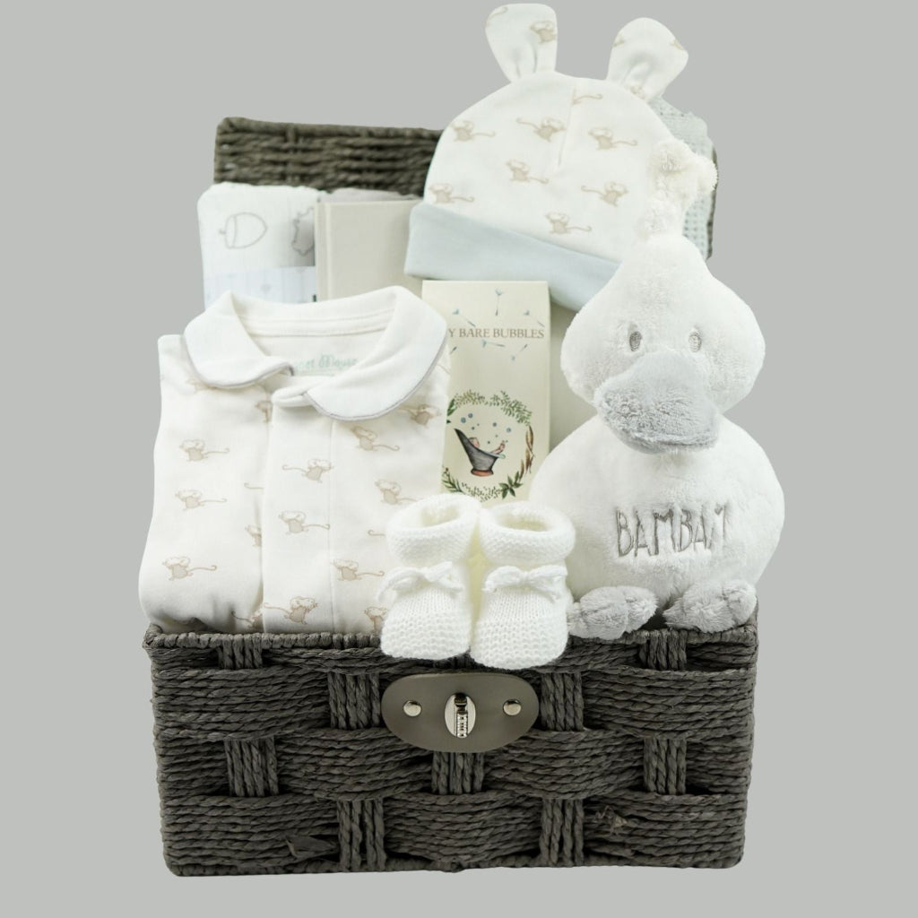 baby hamper basket with soft whit duck rattle with grey beak, baby clothing set in white with grey mice and magnetic fastenings, 2 muslin swaddles, baby toletries, cute hat with ears baby booties 