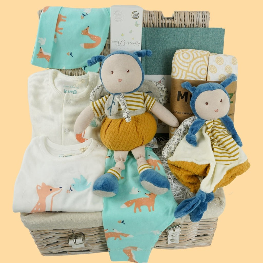 Baby hamper with organic clothing set includes baby sleepsuit in white with fox and dove design, baby bodysuit with long sleeves and fox and dove design, baby leggings with fox and matching hat, Organic cotton bee soft toy and  matching comforter, organic cotton white swaddles with yellow design, green baby journal, organic baby toiletries 