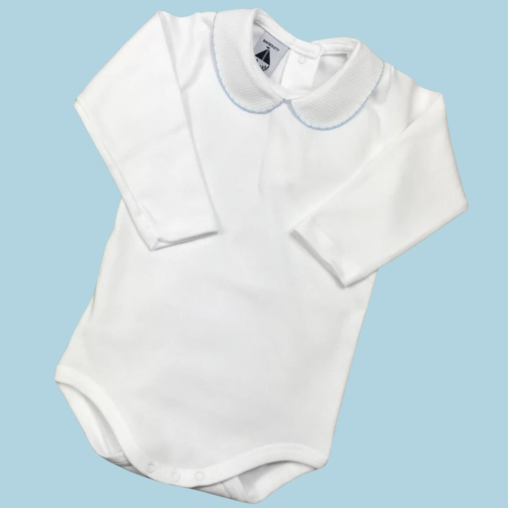 white spanish baby vest with peterpan collar trimed with pale blue edging 