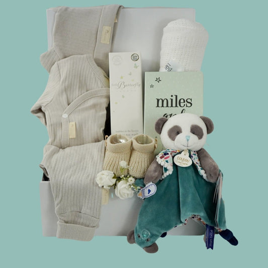 Neutral Baby hamper, baby organic cream outfit with hat, baby leggings and wrap over baby bodysuit, organic toiletries, knit booties, white blanket, miles and moments cards , panda comforter 